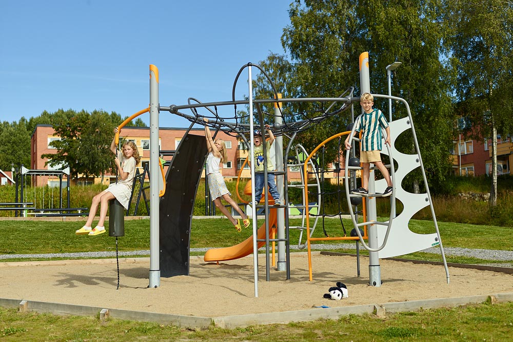 Ett gäng glada barn leker i en klätterställning. Bild.