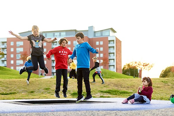 Barn hoppar studsmatta i en lekpark i Nacksta